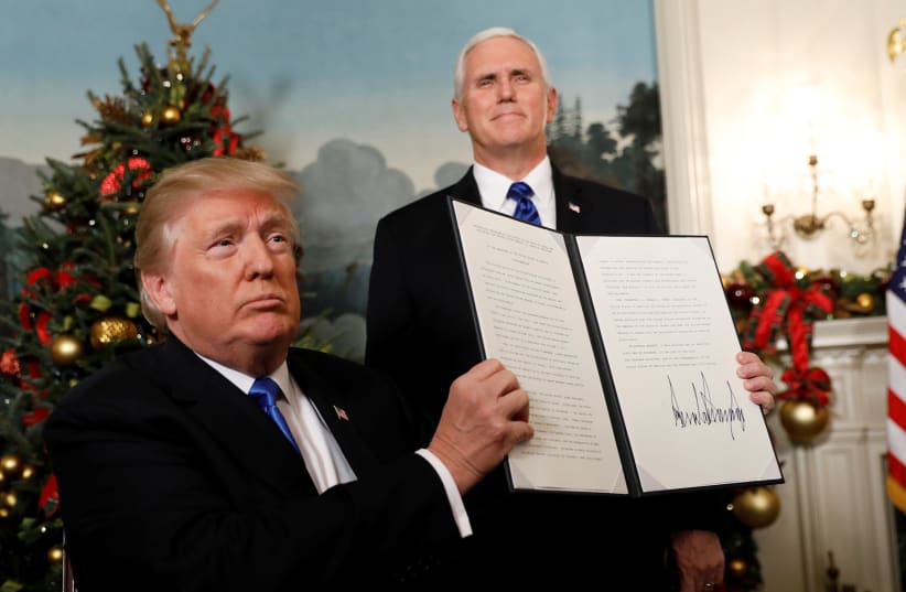 After signing, US President Donald Trump holds up the proclamation that the United States recognizes Jerusalem as the capital of Israel and will move its embassy there, during an address from the White House in Washington, US, December 6, 2017. (photo credit: REUTERS)