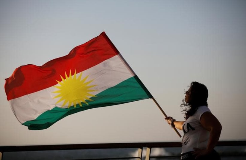 An Israeli woman of Kurdish origin holds a Kurdish flag (photo credit: REUTERS/AMIR COHEN)