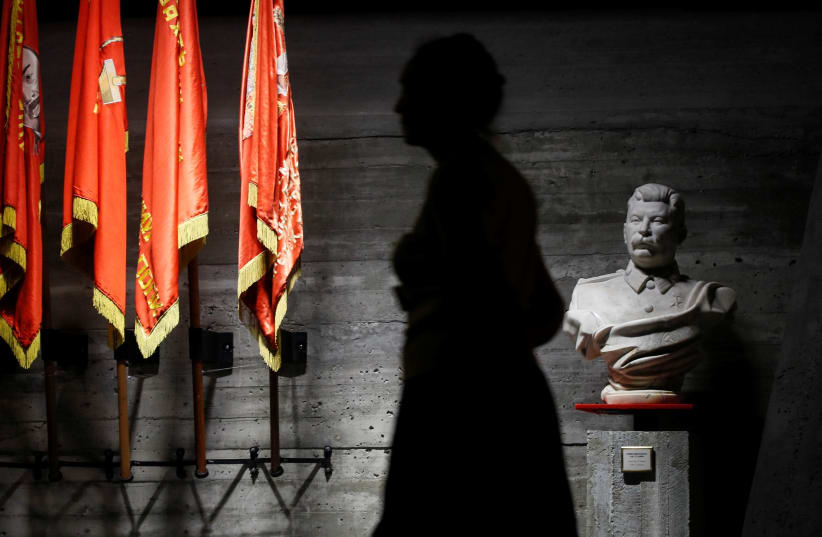 A woman walks past a bust of Soviet leader Joseph Stalin in an exhibit dedicated to the Battle of Stalingrad (photo credit: REUTERS/MAXIM SHEMETOV)