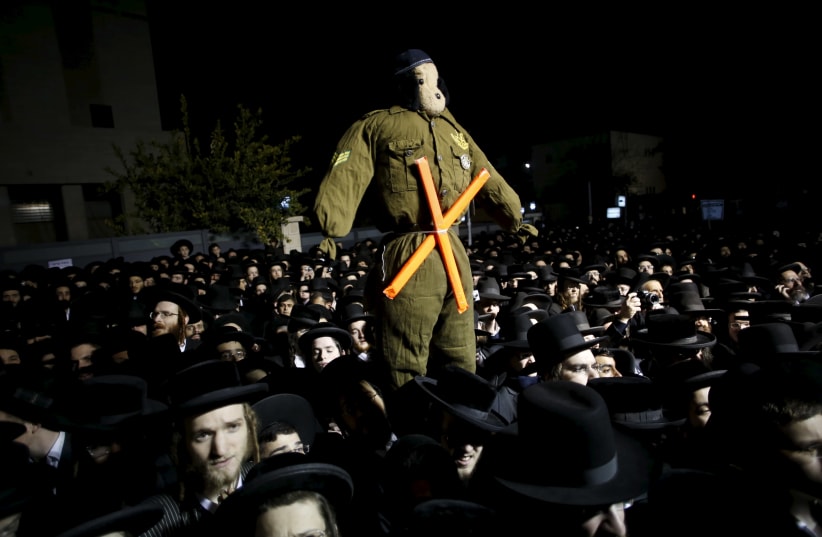 Ultra-Orthodox Jews attend a protest against a law calling for members of their community to serve in the army. (photo credit: REUTERS)