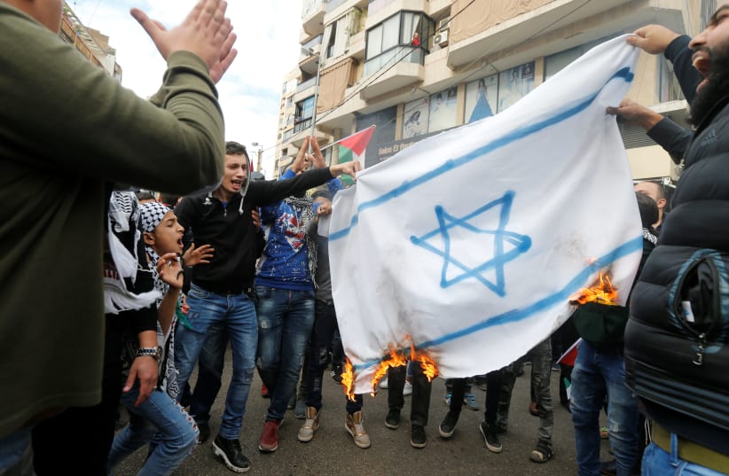 Protestors burn a makeshift Israeli flag in Beirut, Lebanon (photo credit: MOHAMED AZAKIR / REUTERS)