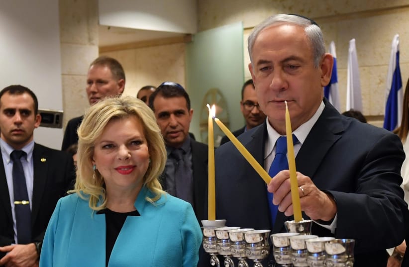 Prime Minister Benjamin Netanyahu and his wife Sara Netanyahu light the first candle of Hanukkah at the Israeli Ministery of Foreign Affairs Jerusalem  (photo credit: HAIM ZACH/GPO)