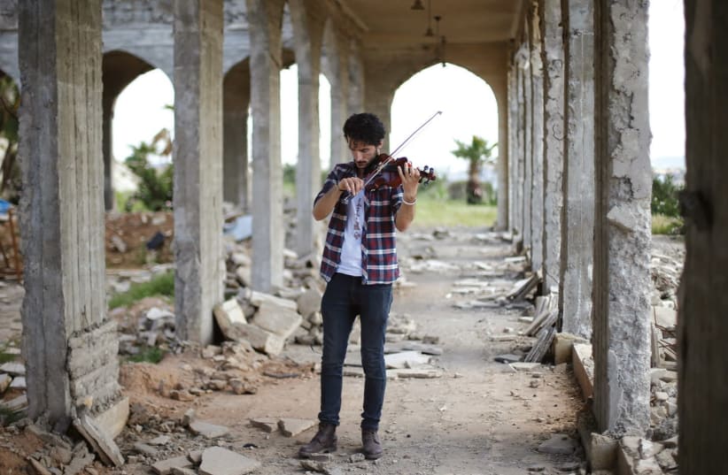 A VIOLINIST in Mosul plays in the ruins of a building after liberation from Islamic State. (photo credit: REUTERS)