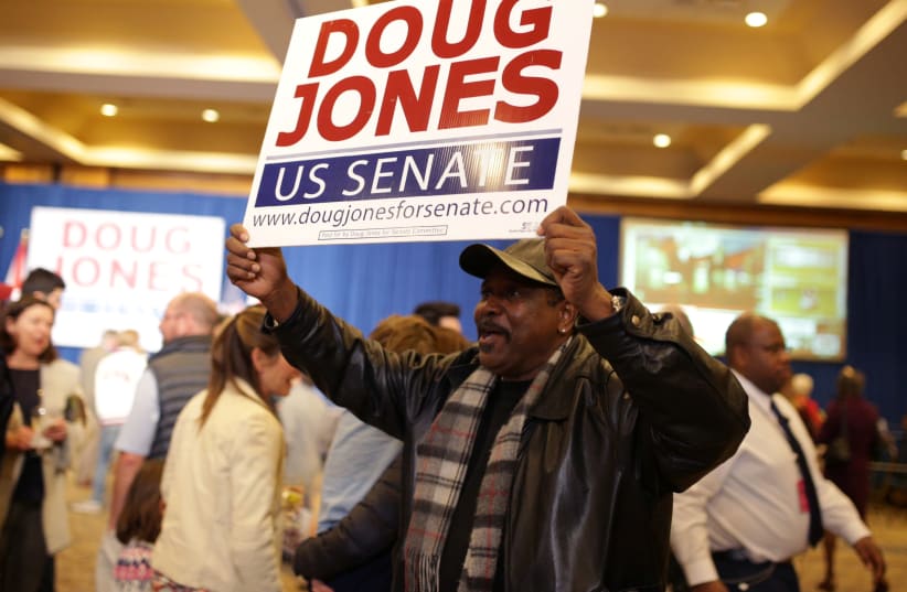A supporter holds sign during Democratic US Senate candidate Doug Jones' election night party in Birmingham, Alabama. (photo credit: MARVIN GENTRY/REUTERS)