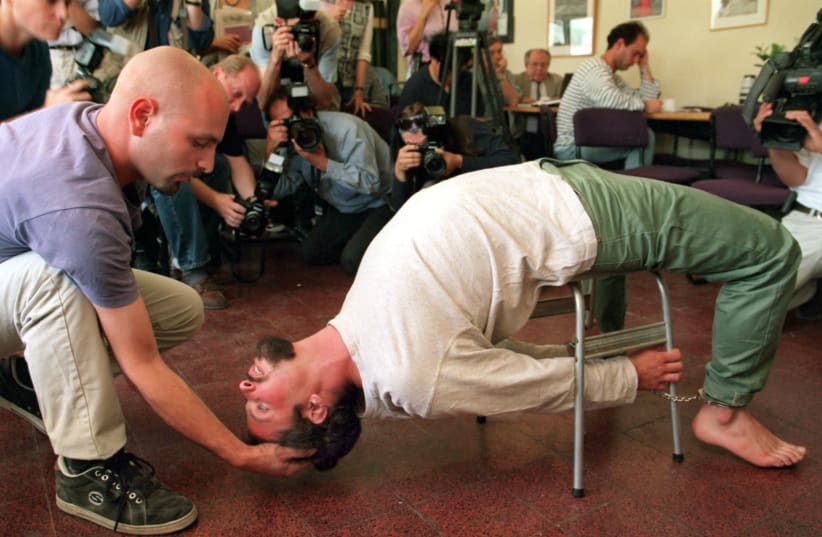 Actors demonstrate the Israeli Shin Bet torture method known as "Banana b'kiseh" (photo credit: DAVID SILVERMAN / REUTERS)