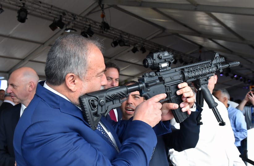 Defense Minister Avigdor Liberman holds a weapon during a visit to Sderot (photo credit: ARIEL HERMONI / DEFENSE MINISTRY)