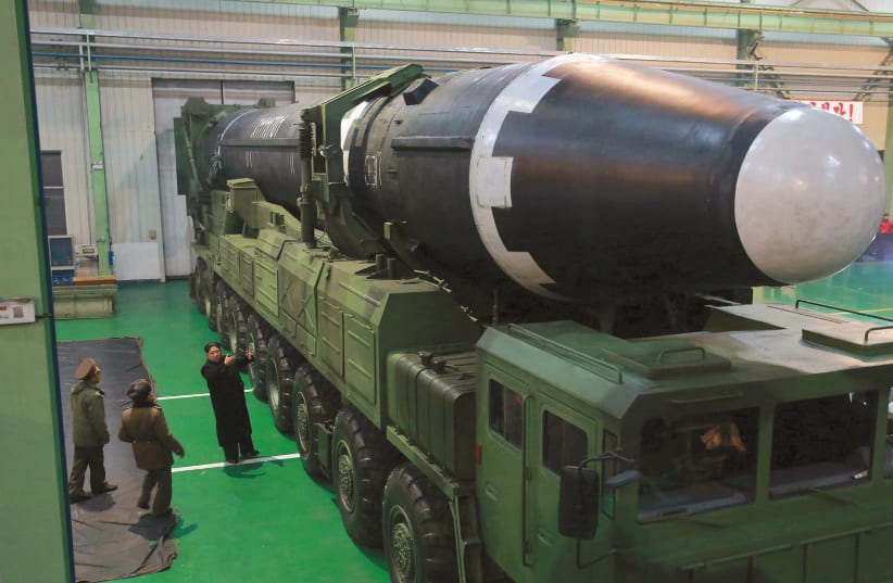 NORTH KOREA’S leader Kim Jong Un gestures beside the newly developed intercontinental ballistic rocket Hwasong-15, in an undated photo released by North Korea’s Korean Central News Agency in November. (photo credit: REUTERS)