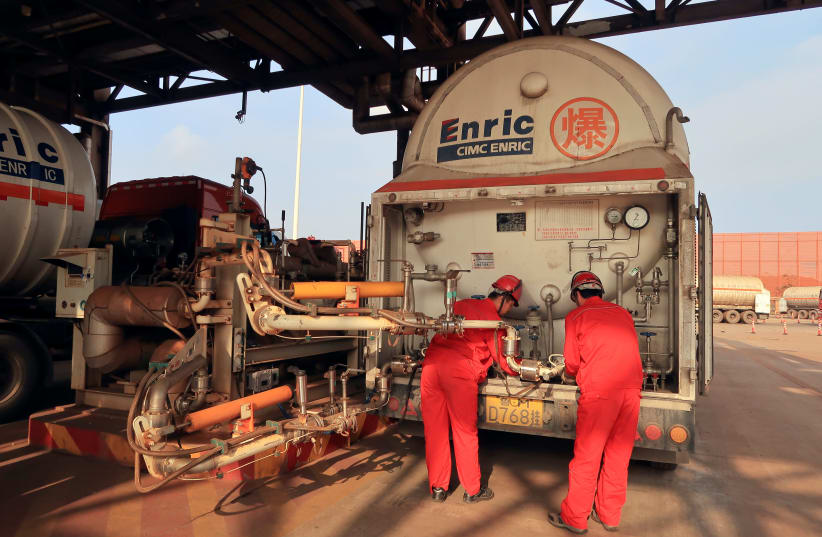 Workers get ready to pump liquefied natural gas into a gas trailer at CNPC Caofeidian terminal, in Tangshan, Hebei province, China. (photo credit: REUTERS)