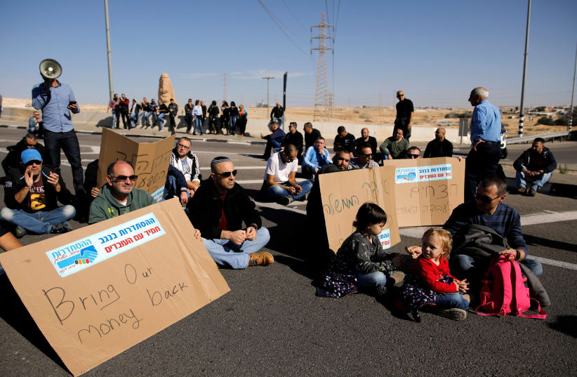 Teva Pharmaceutical Industries workers block a road during a demonstration near the facility in Neot Hovav, southern Israel December 17, 2017 (photo credit: REUTERS/AMIR COHEN)