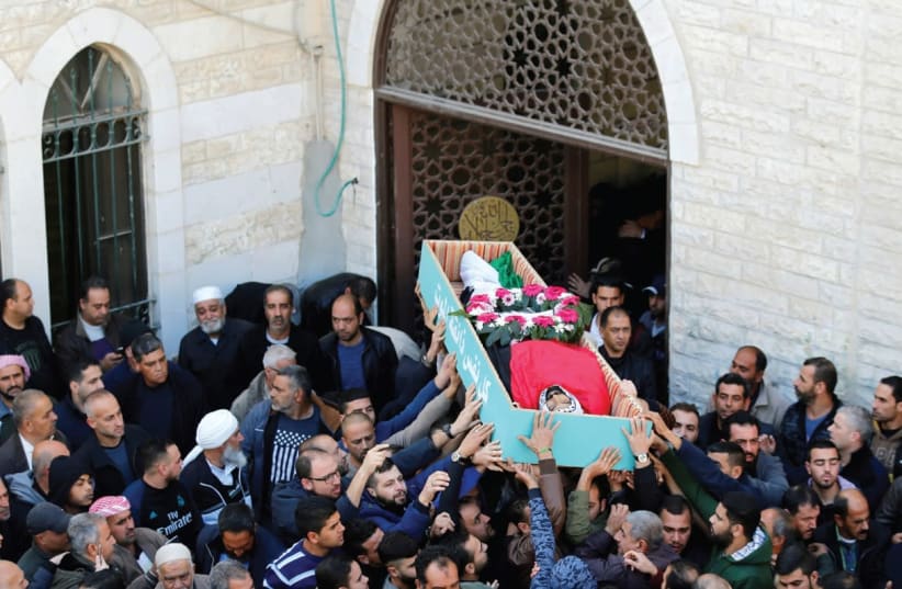 Palestinians carry the body of Basel Mustafa Ibrahim, killed during anti-Israel rioting, during his funeral Saturday in the village of Anata, which borders Jerusalem (photo credit: AMMAR AWAD / REUTERS)