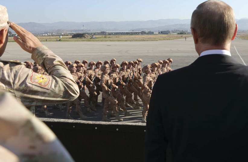 RUSSIAN PRESIDENT Vladimir Putin (right) and Defense Minister Sergei Shoigu watch Russian soldiers passing by as they visit the Hmeymim air base in Latakia Province, Syria, December 2017 (photo credit: REUTERS)