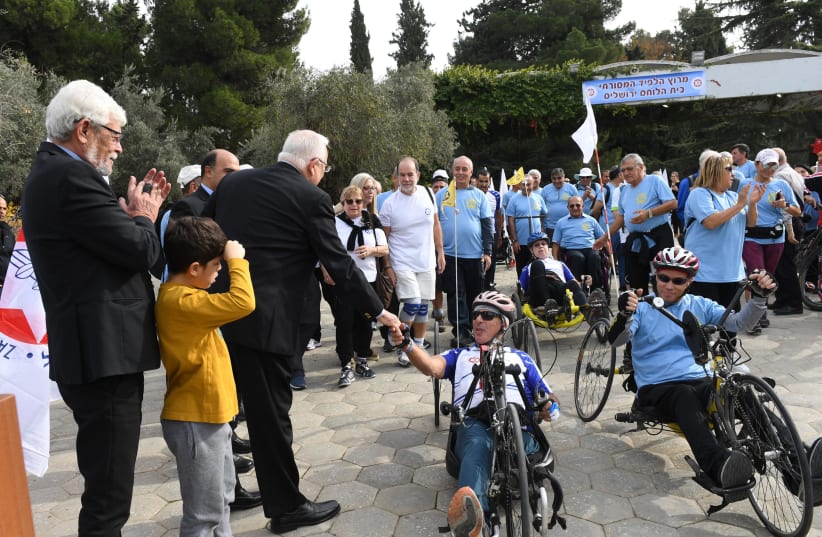 President Reuven Rivlin meets disabled veteran cyclists in Jerusalem (photo credit: CHAIM TZACH/GPO)