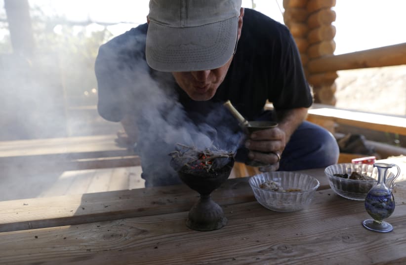 Guy Erlich, an Israeli entrepreneur, demonstrates the burning of dried and crushed resins of three plants, frankincense, myrrh and Balsam of Gilead in Kibbutz Almog, Judean desert, in the West Bank (photo credit: REUTERS)