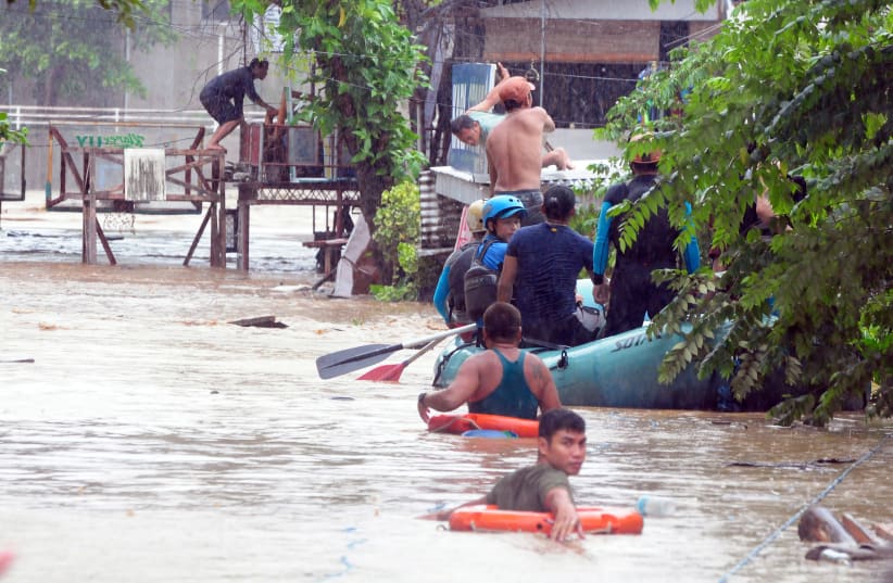 Rescuers evacuate residents from their homes during heavy flooding in Cagayan de Oro city in the Philippines, December 22, 2017. (photo credit: REUTERS)