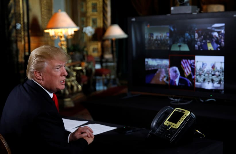US President Donald Trump participates in a Christmas Eve video teleconference with members of the military at Mar-a-Lago estate in Palm Beach, Florida (photo credit: CARLOS BARRIA / REUTERS)