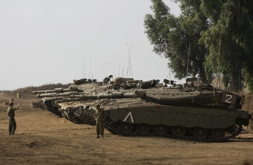 An Israeli soldier directs a tank during an exercise in the Golan Heights. (photo credit: REUTERS)