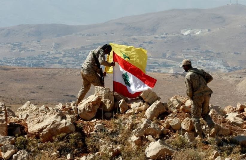 Hezbollah fighters put Lebanese and Hezbollah flags at Juroud Arsal, Syria-Lebanon border, July 25, 2017 (photo credit: REUTERS/MOHAMED AZAKIR)