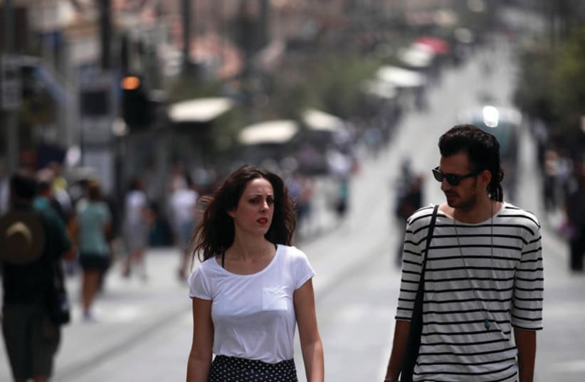 A young couple walk down Jerusalem’s Jaffa Road (photo credit: MARC ISRAEL SELLEM)
