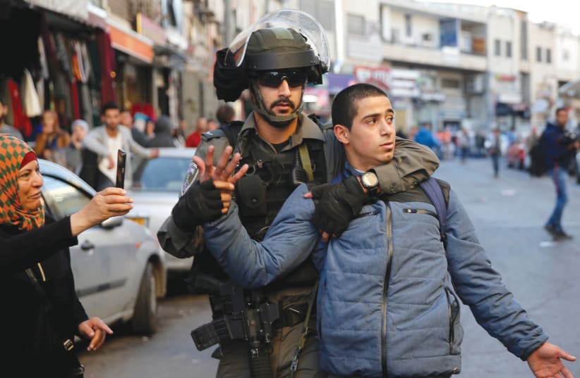 An Israeli border police officer detains a Palestinian protester during a demonstration in east Jerusalem on December 16 (photo credit: AMMAR AWAD/REUTERS)