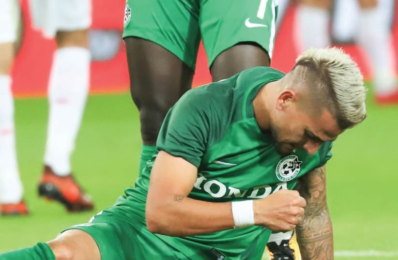 Maccabi Haifa midfielder Maor Buzaglo thumped the ground in frustration night after re-injuring his right knee, one month after coming back from a seven-month layoff (photo credit: DANNY MAROM)