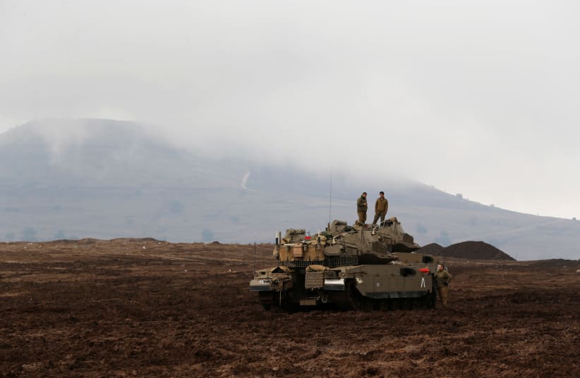 Israeli soldiers stand atop tanks in the Israeli Golan Heights, close to Israel's frontier with Syria November 22, 2017 (photo credit: REUTERS/AMMAR AWAD)