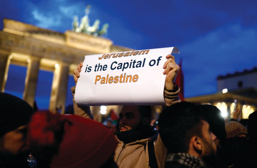 A PROTESTER holds a placard during the demonstration outside the US embassy in Berlin against President Donald Trump’s decision to recognize Jerusalem as Israel’s capital (photo credit: AXEL SCHMIDT/REUTERS)