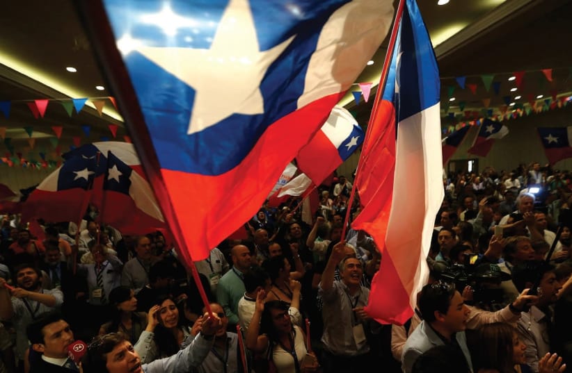 CHILEANS RAISE their flag during a political campaign earlier this month.  (photo credit: REUTERS)