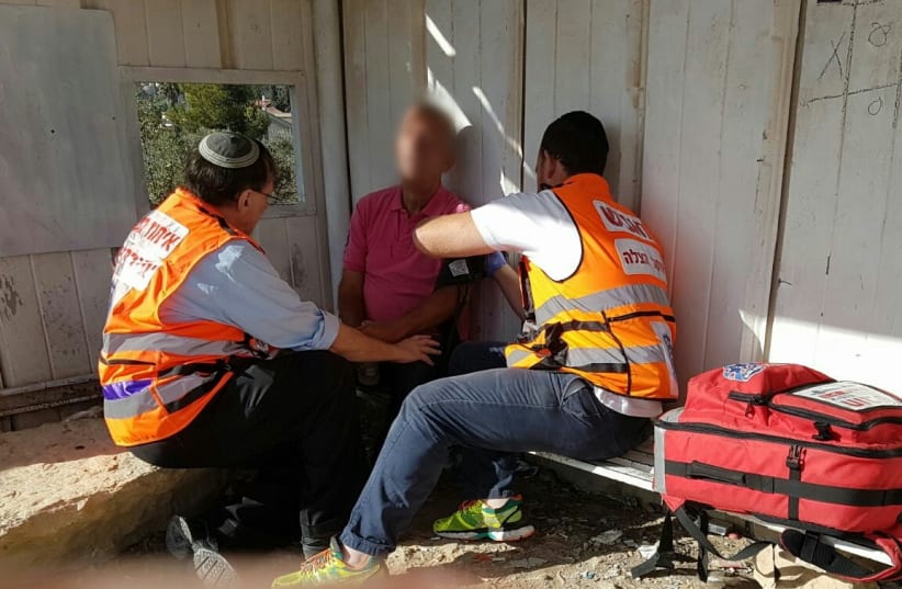 Psycho-trauma and Crisis Response Unit volunteers aid an Israeli suffering from shock (photo credit: UNITED HATZALAH‏)