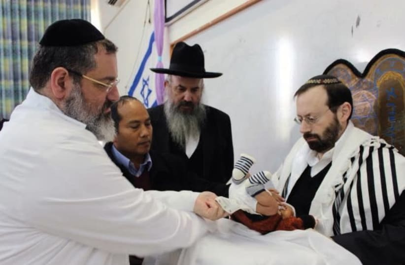 MICHAEL FREUND serves as the ‘sandak’ or godfather at the circumcision ceremony for Ovadiah Daniel Lunghel. (photo credit: Courtesy)