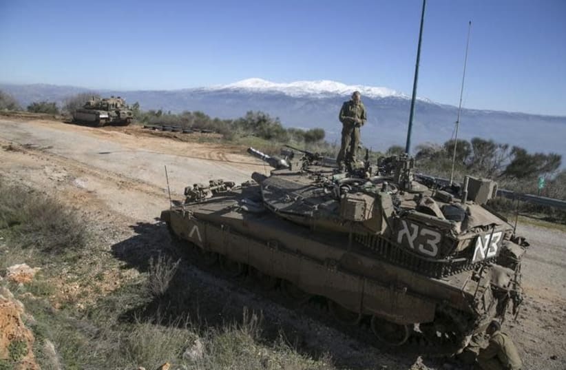 An Israeli soldier stands atop a tank near Israel's border with Lebanon January 21, 2015 (photo credit: REUTERS/BAZ RATNER)