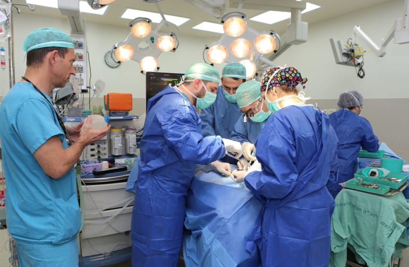A Rambam surgical team working to seperate the congenitally fused jaws of an infant. (photo credit: PIOTR FLITR FOR RAMBAM)