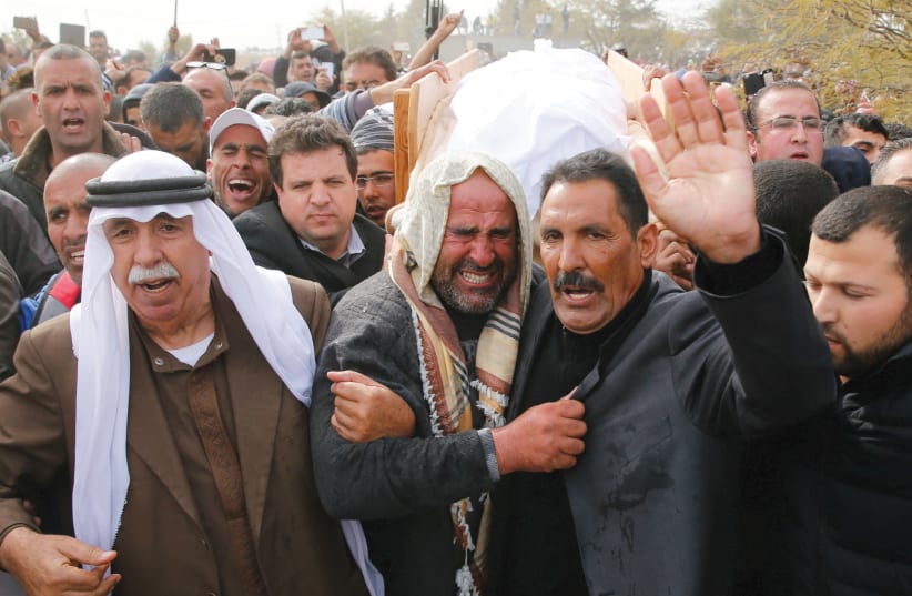 FRIENDS AND RELATIVES carry the body of Ya’qoub Abu al-Qi’an during his funeral in the Beduin village of Umm al-Hiran in the Negev. (photo credit: AMMAR AWAD / REUTERS)