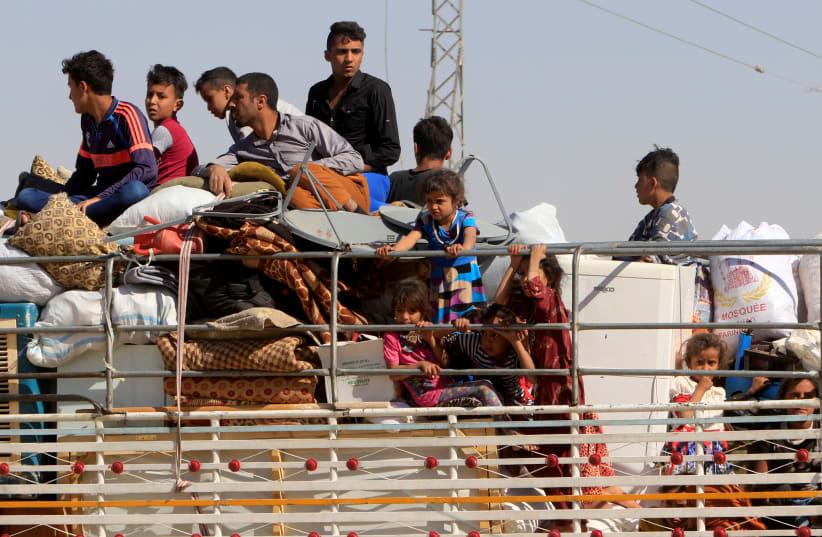 Displaced people riding in trucks and cars head back to their homes in Hawija, on the outskirts of Kirkuk, Iraq in October (photo credit: REUTERS/ALAA AL-MARJANI)