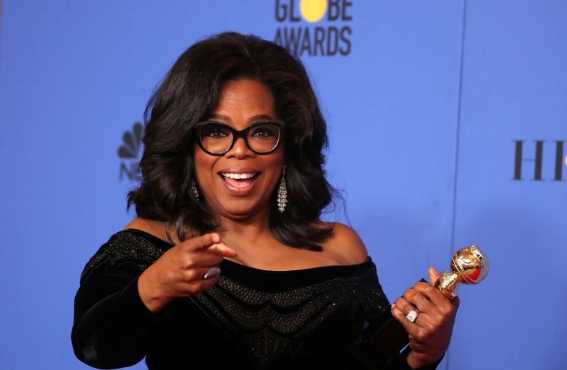 Oprah Winfrey poses backstage with her Cecil B. DeMille Award (photo credit: LUCY NICHOLSON / REUTERS)