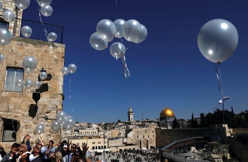 People release balloons as they celebrate a bar mitzva near the Western Wall (photo credit: RONEN ZVULUN / REUTERS)