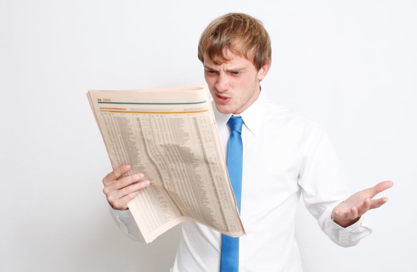 Man reads newspaper in frustration. (photo credit: INGIMAGE)