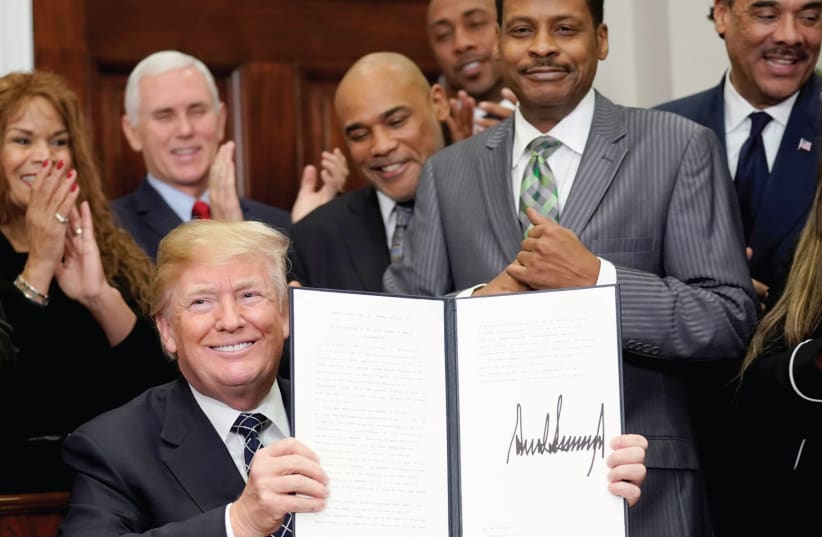 US President Donald Trump holds up a proclamation honoring Martin Luther King Jr. in the White House in January of 2018 (photo credit: JOSHUA ROBERTS / REUTERS)