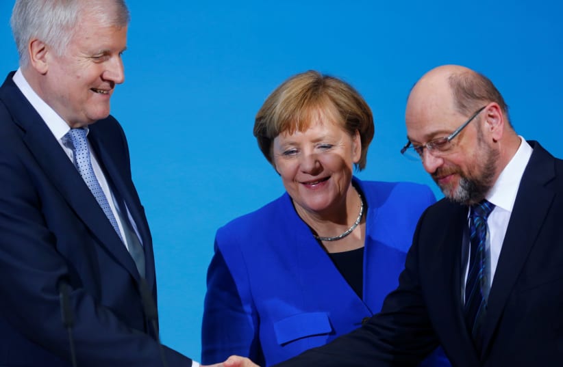 Acting German Chancellor Angela Merkel, leader of the Christian Social Union in Bavaria (CSU) Horst Seehofer and Social Democratic Party (SPD) leader Martin Schulz shake hands during a news conference. (photo credit: REUTERS)