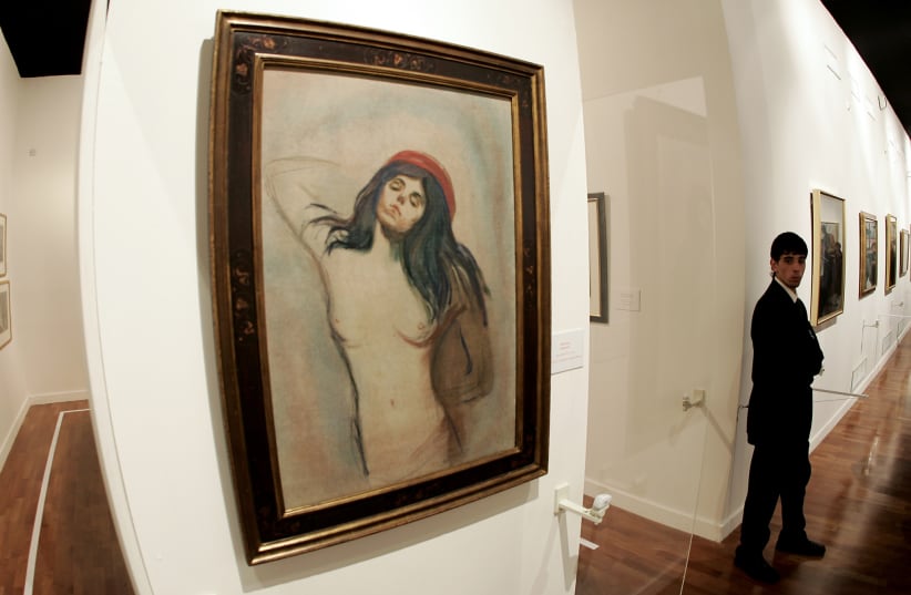 A security guard stands near a painting of " Madonna" by Norwegian artist Edvard Munch (photo credit: REUTERS/ALESSANDRO BIANCHI)