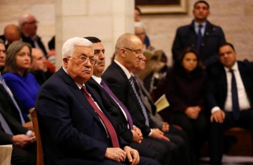 Palestinian President Mahmoud Abbas attends a Christmas midnight mass at the Church of the Nativity in the West Bank city of Bethlehem, December 25, 2017 (photo credit: MUSSA QAWASMA / REUTERS)
