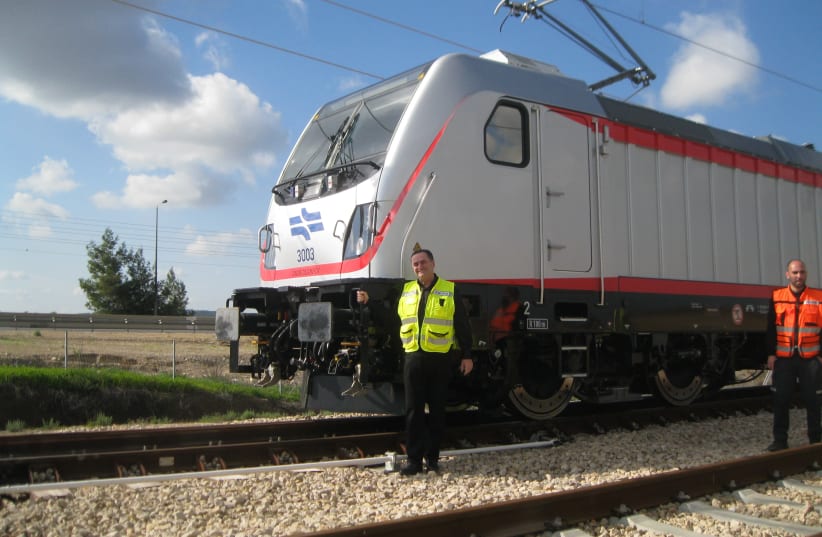 Transportation Minister Israel Katz stands next to the electric locomotive that hauled test train on January 15, 2018 (photo credit: SYBIL EHRLICH)