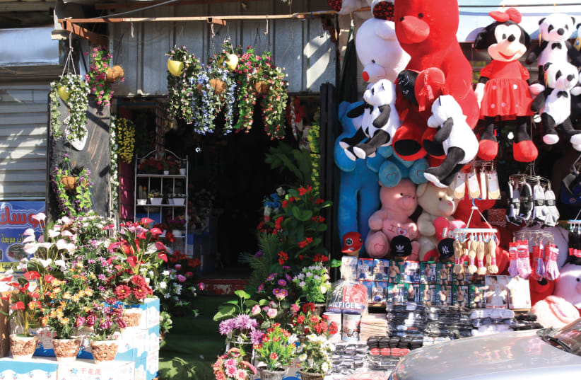 SHOPS IN Barta’a offer all sorts of kitsch, household goods, and clothing – toys, cosmetics, socks, plants, stuffed animals, plastic slippers and  oral head scarves (photo credit: FRANZISKA KNUPPER)