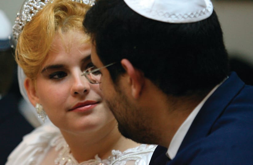 A COUPLE looks at each other while waiting to get married at Havana’s Beth Shalom synagogue in 2007 (photo credit: CLAUDIA DAUT/REUTERS)