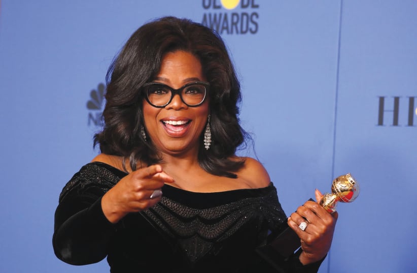 Oprah Winfrey poses backstage with her Cecil B. DeMille Award at the 75th Golden Globe Awards in Beverly Hills, California, last week (photo credit: REUTERS/LUCY NICHOLSON)