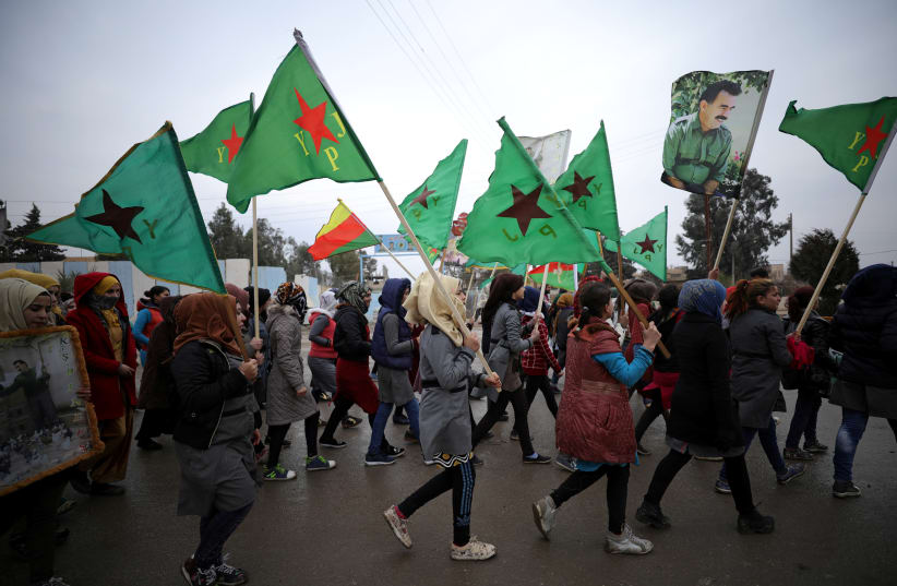 People hold flags of Women's Protection Unit (YPJ) as they walk during a protest against Turkish attacks on Afrin, in Hasaka, Syria, January 18, 2018. (photo credit: RODI SAID / REUTERS)