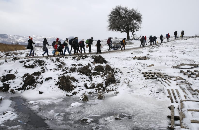 Migrants cross a snowy field, January 2016 (photo credit: MARKO DJURICA / REUTERS)