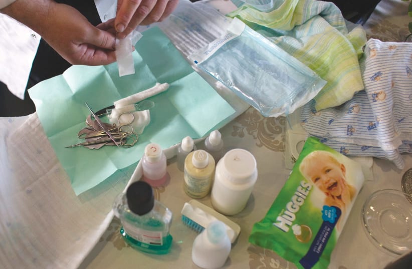 A man prepares the items needed for a circumcision. (photo credit: REUTERS)