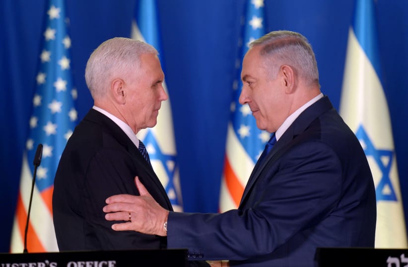Prime Minister Benjamin Netanyahu and United States Vice President Mike Pence embrace during joint speeches on January 22, 2018. (photo credit: AVI OHAYON - GPO)