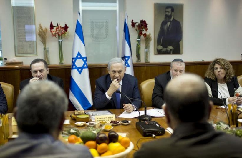 sraeli Prime Minister Benjamin Netanyahu (C) eats fruits and nuts as he marks Tu Bishvat, the Jewish Arbor Day, during the weekly cabinet meeting at his office in Jerusalem January 24, 2016. (photo credit: ABIR SULTAN / REUTERS)