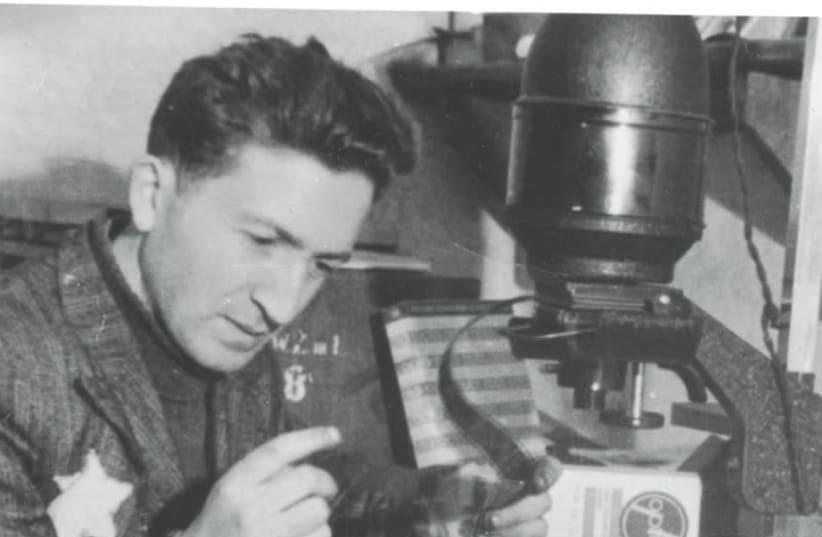 MENDEL GROSSMAN works in his photography lab in the Lodz Ghetto. Many of Grossman’s photos depict the suffering in the ghetto and were found after the war, outliving their creator.  (Yad Vashem Photo Archives) (photo credit: COURTESY: YAD VASHEM PHOTO ARCHIVE)
